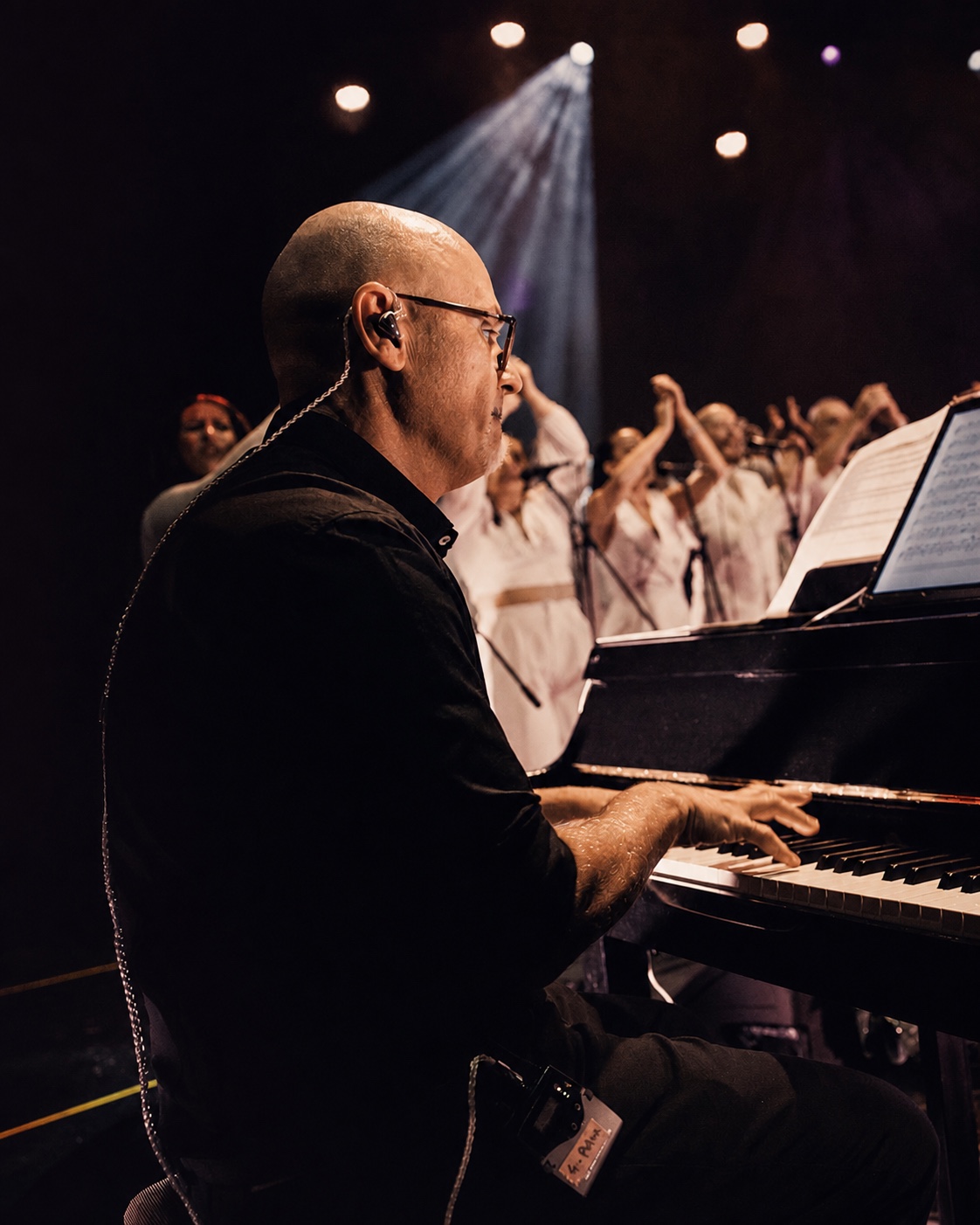Pino Di Pietro al pianoforte con il coro sul palco