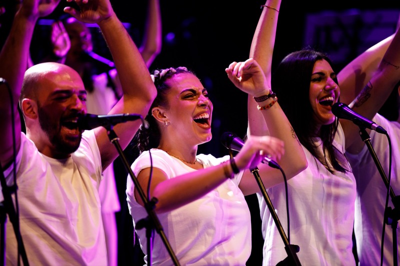 Tre voci di LV Gospel Project cantano dal vivo con le braccia alzate